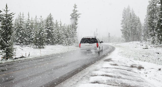 A car driving through a snowy road.