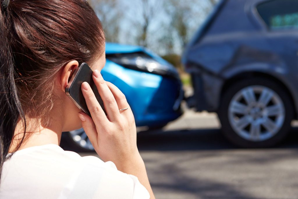 A car accident. A woman is talking on a phone.